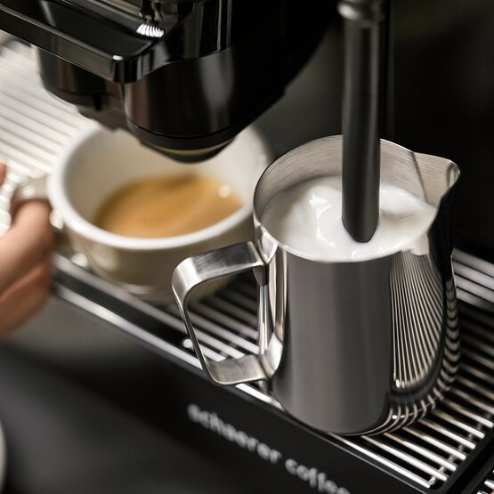 Kávovar Schaerer v provozu, pění mléko a vaří espresso pro dokonalý zážitek z kávy.