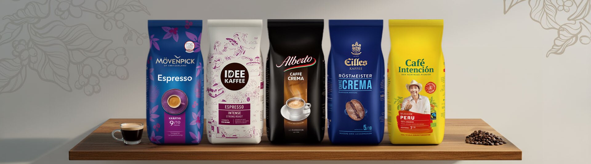 Výber prémiových vrecúšok s kávou, vrátane Espresso a Caffè Crema, vystavených na drevenej polici s kávovými zrnami.
