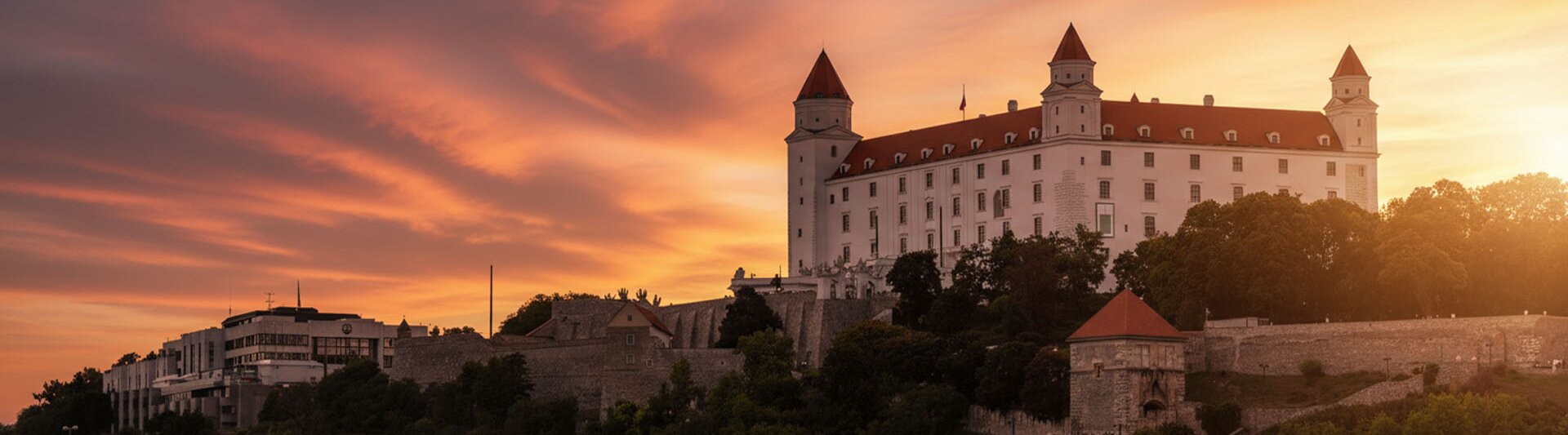 Bratislavský hrad osvetlený nádherným západom slnka, ktorý ukazuje jeho historickú architektúru na pozadí žiarivej oblohy.