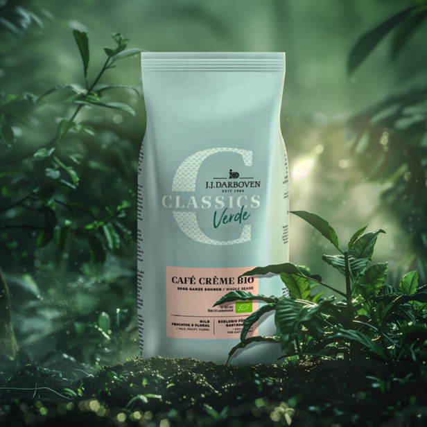 Udržitelný obal J.J. Darboven Café Crème Bio obklopený bujnou zelení, zdůrazňující celá zrna a bio kvalitu.