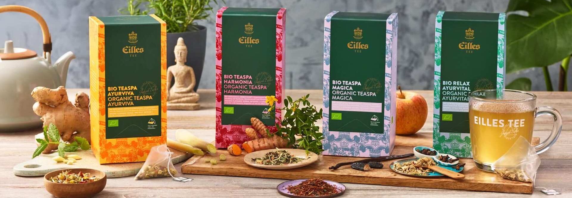 Organické ájurvédské směsi Eilles Tea, včetně Relax, Magica a Harmonia, zobrazené s čerstvými ingrediencemi.