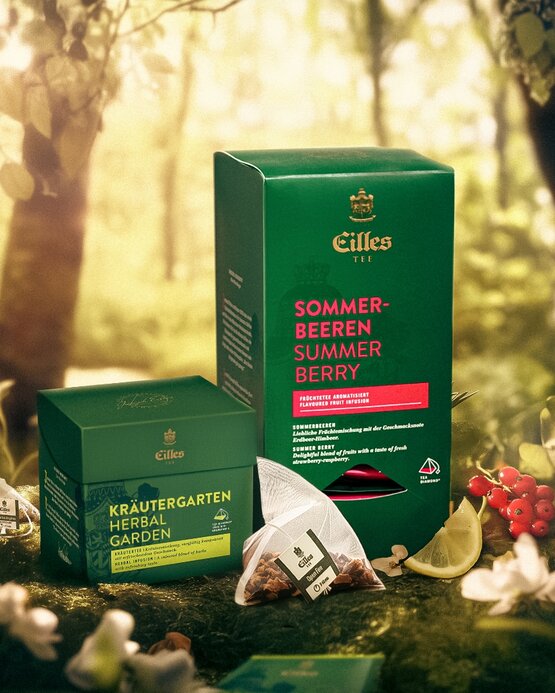 Organické bylinné čaje Eilles, včetně čajů Summer Berry a Herbal Garden, zobrazené na pozadí svěžího lesa.