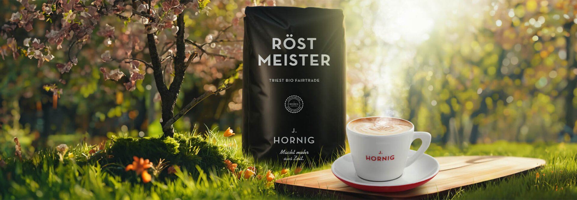 Balení kávy Röst Meister vedle šálku s párou na dřevěné desce, obklopené rozkvetlými květinami a svěží zelení.