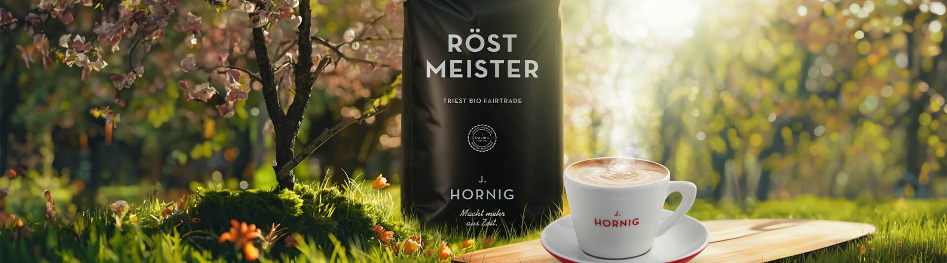 Balenie kávy Röst Meister vedľa pariacej sa šálky na drevenej doske, obklopené rozkvitnutými kvetmi a sviežou zeleňou.