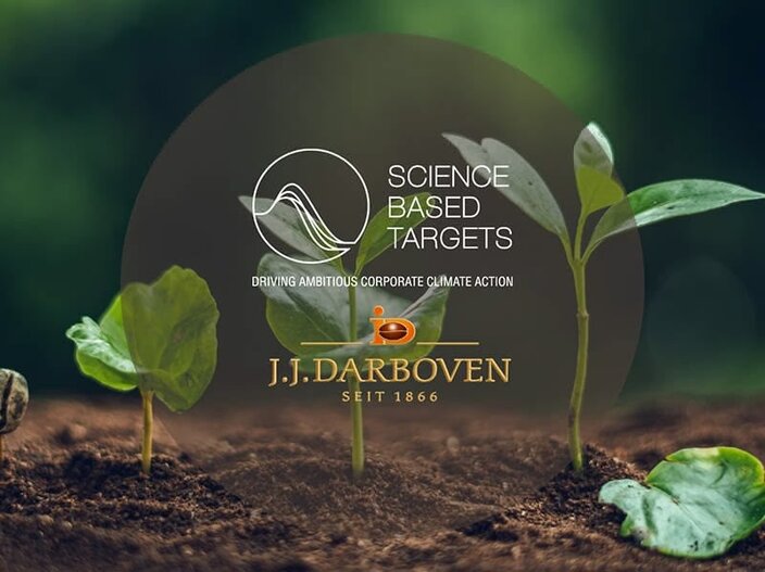 Rostliny rostoucí v půdě s logem "Science Based Targets" a logem "J.J. Darboven", zdůrazňující opatření podniků v oblasti klimatu.