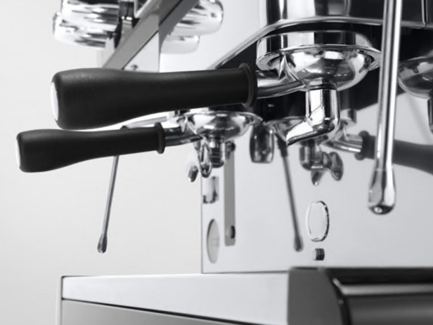 Detailní záběr chromovaného kávovaru s elegantními rukojeťmi a leštěnými úchyty, který je ideální pro milovníky kávy.