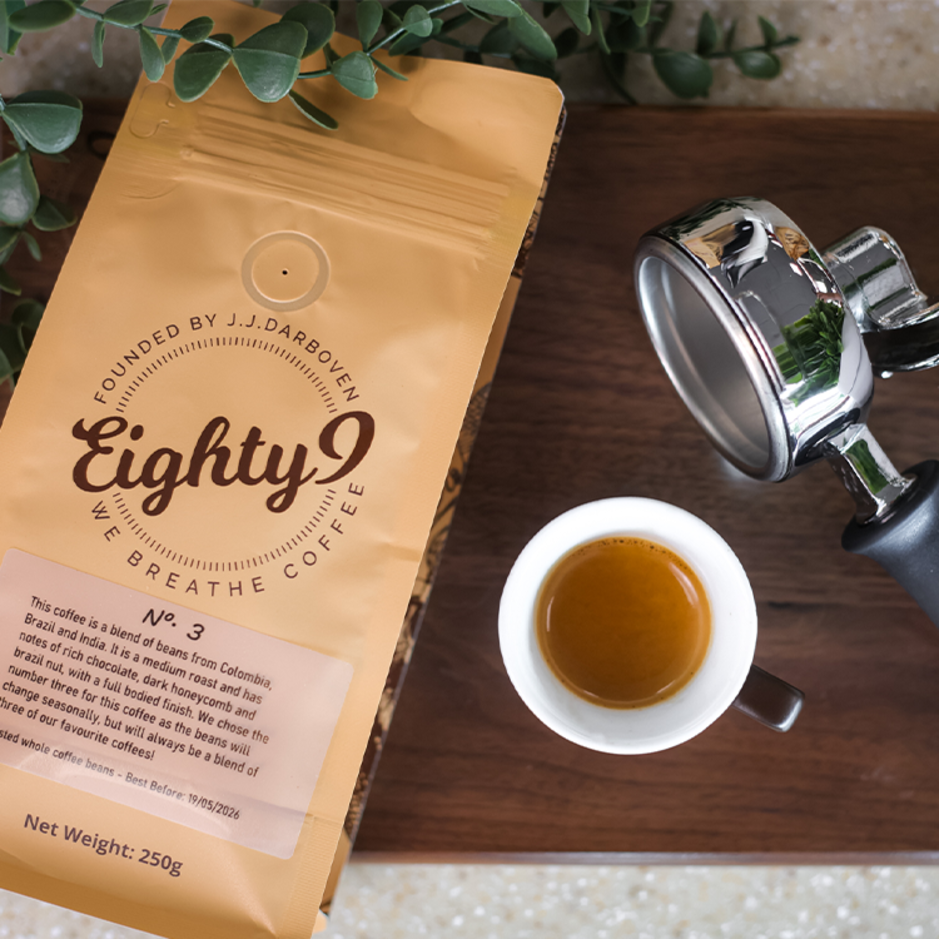 Freshly brewed espresso next to Eighty9 coffee bag, showcasing premium blends from Colombia and Brazil.