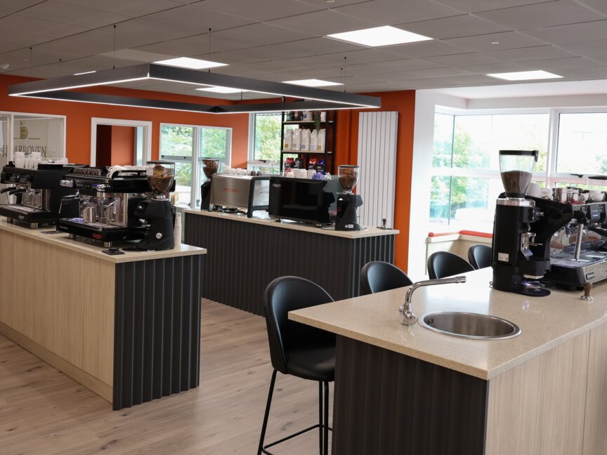 Modern coffee brewing area featuring multiple espresso machines and a bright, inviting atmosphere. Ideal for coffee enthusiasts.