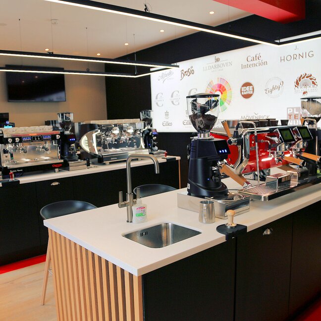 Modern coffee shop interior featuring espresso machines, grinders, and a stylish counter for fresh brews.