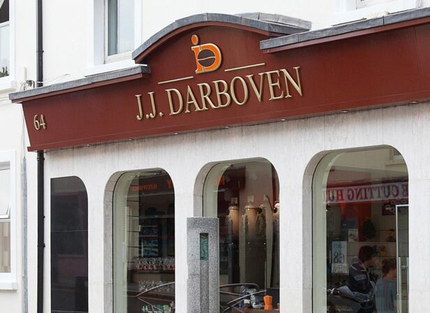 Facade of J.J. Darboven, a retail shop showcasing products, with stylish architecture and glass windows in view.