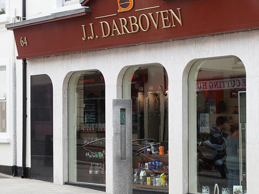 Facade of J.J. Darboven, a retail shop showcasing products, with stylish architecture and glass windows in view.