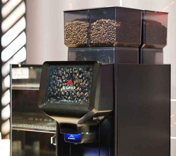 Egro NEXT Touch coffee machine featuring a touchscreen display and visible coffee beans in containers above.