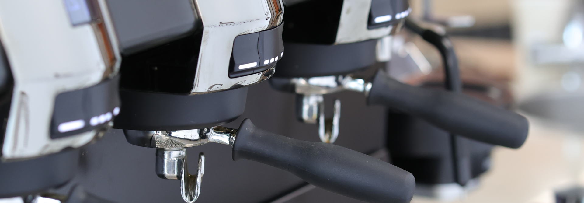 Sleek coffee machine with multiple espresso handles and a polished drip tray, ideal for coffee enthusiasts.