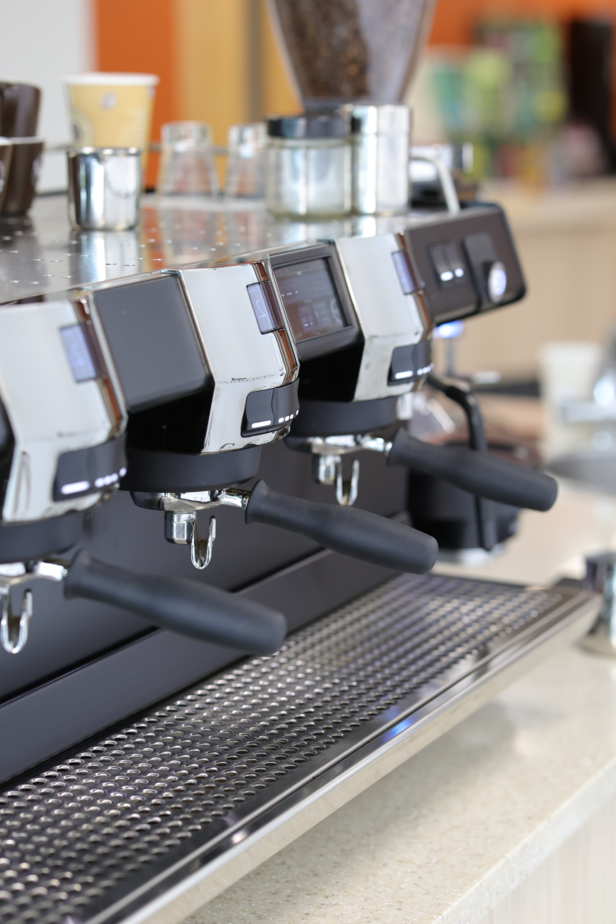 Sleek coffee machine with several group heads, showcasing a modern café setup for expertly brewed espresso.