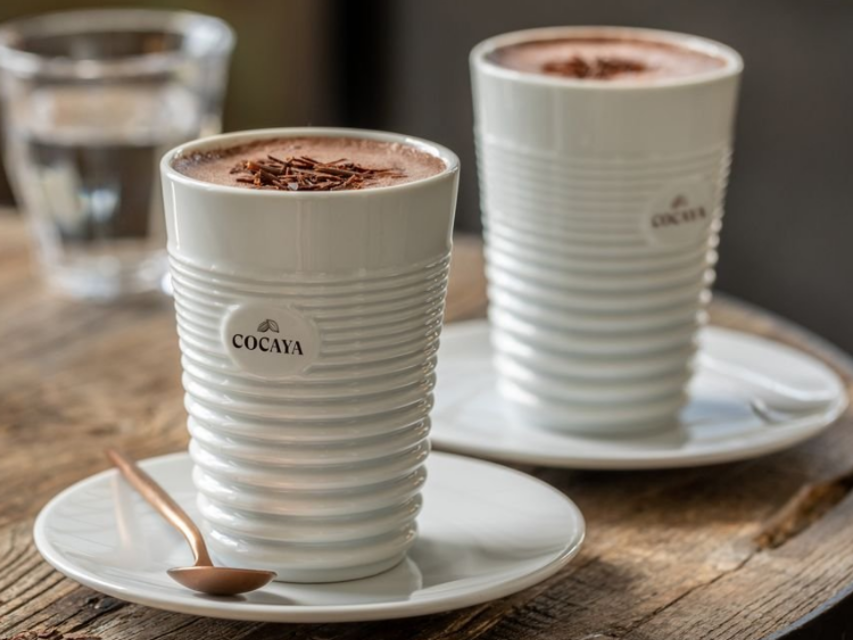 Hot chocolate served in elegant Cocaya cups, accompanied by a spoon on rustic wooden table. Perfect for cosy moments.