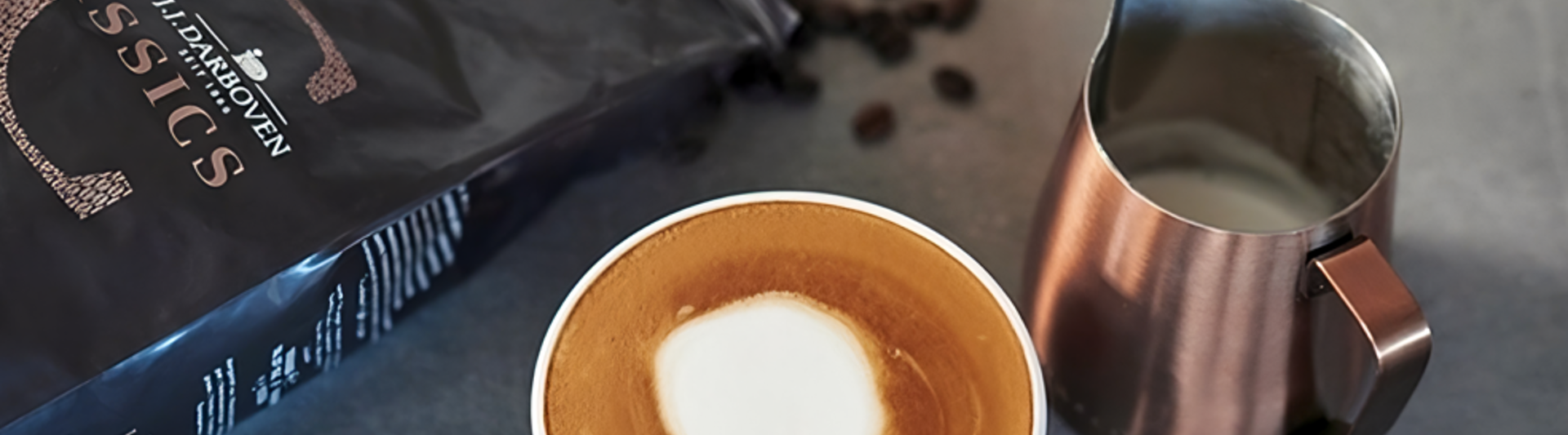 L'art du latte crémeux se trouve à côté de grains de café et d'un pot à lait, parfait pour les amateurs de café et les passionnés de cafés.