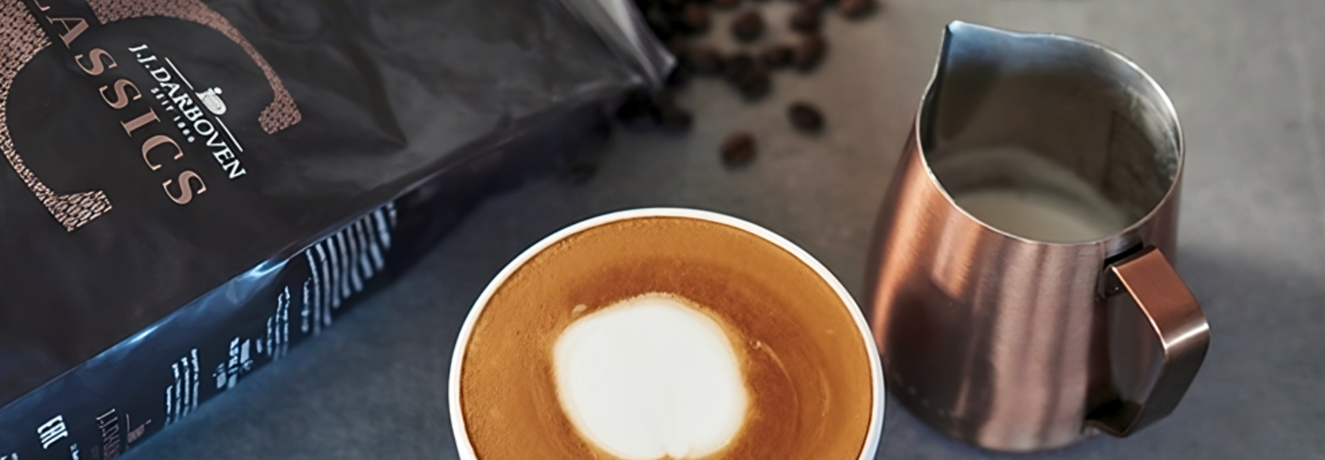 L'art du latte crémeux se trouve à côté de grains de café et d'un pot à lait, parfait pour les amateurs de café et les passionnés de cafés.