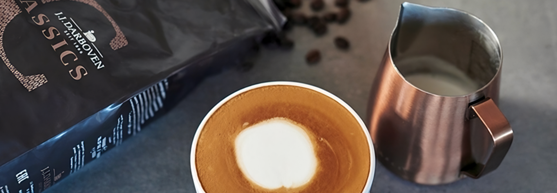 L'art du latte crémeux se trouve à côté de grains de café et d'un pot à lait, parfait pour les amateurs de café et les passionnés de cafés.