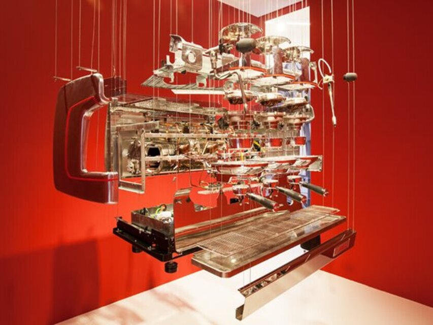 Un modèle 3D détaillé d'une machine à expresso, suspendue sur un fond rouge saisissant. Parfait pour les amateurs de café et les passionnés.