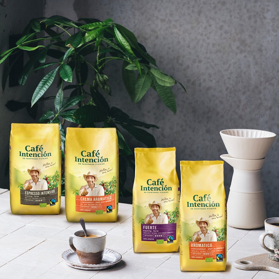 De Fairtrade koffievariëteiten van Café Intención worden getoond met een koffiekopje en zetapparatuur te midden van groen.