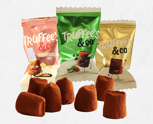 Heerlijke Truffee's &amp; Co. truffels in verschillende smaken, omringd door levendige verpakkingen, perfect voor chocoladeliefhebbers.