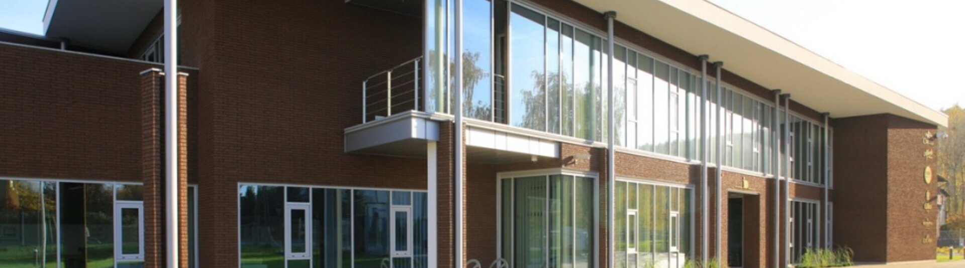Nowoczesny projekt architektoniczny LSA JJDarboven w Rumi, prezentujący duże szklane okna i płaski dach.