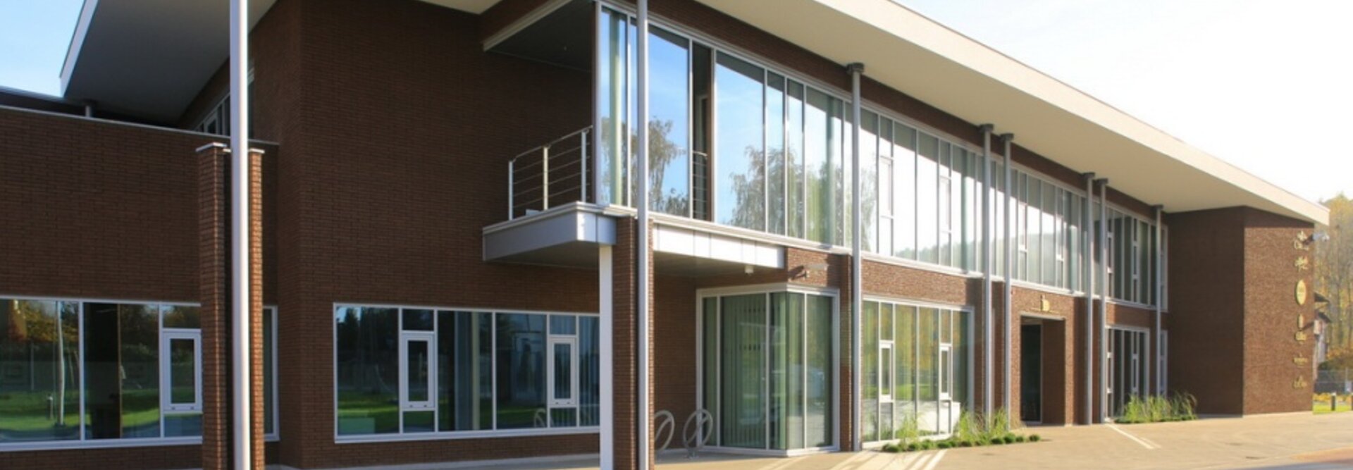 Nowoczesny projekt architektoniczny LSA JJDarboven w Rumi, prezentujący duże szklane okna i płaski dach.