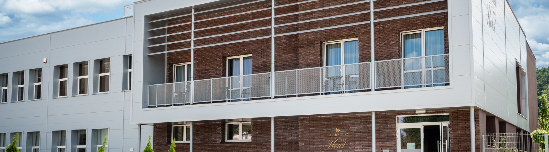 Nowoczesny hotel J.J. Darboven oferuje elegancką architekturę i ogrody krajobrazowe, idealne na relaksujący pobyt.