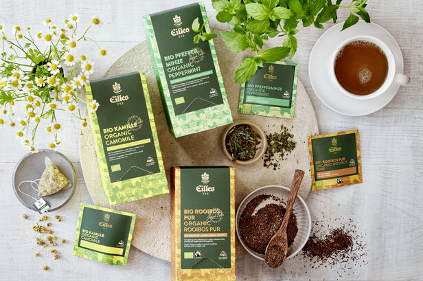 Eilles Bio-Teeauswahl mit Kamille, Pfefferminze und Rooibos, dazu eine Tasse aufgebrühter Tee.