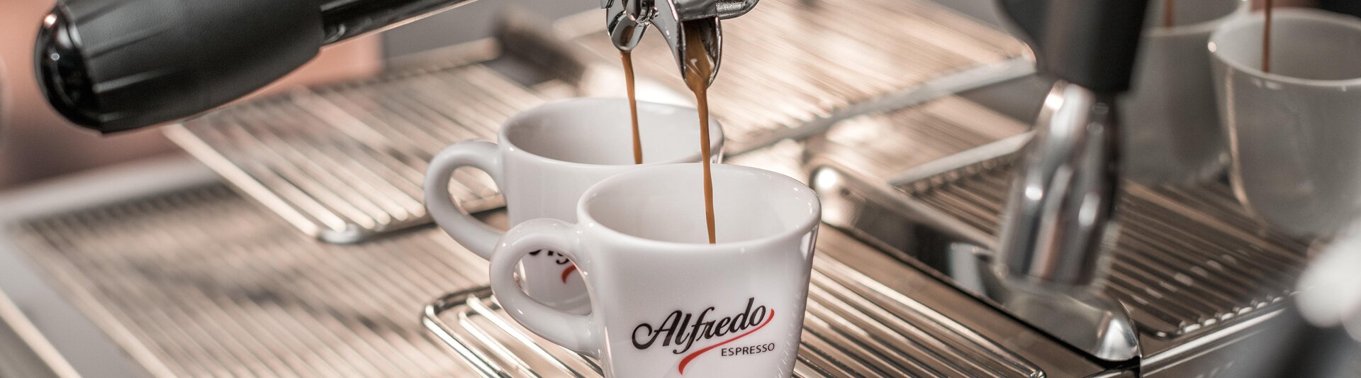 Reichhaltiger Espresso, der aus einer Alfredo-Espressomaschine in zwei Tassen fließt und das perfekte Gebräu eines Kaffeeliebhabers hervorhebt.