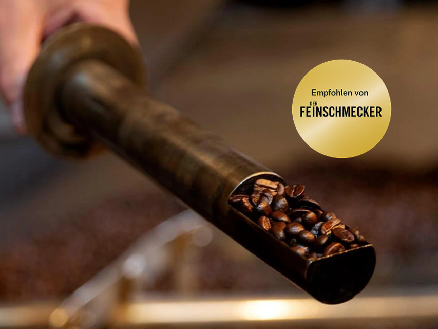 Freshly roasted coffee beans being poured from a roasting tool, showcasing a passion for quality coffee preparation.