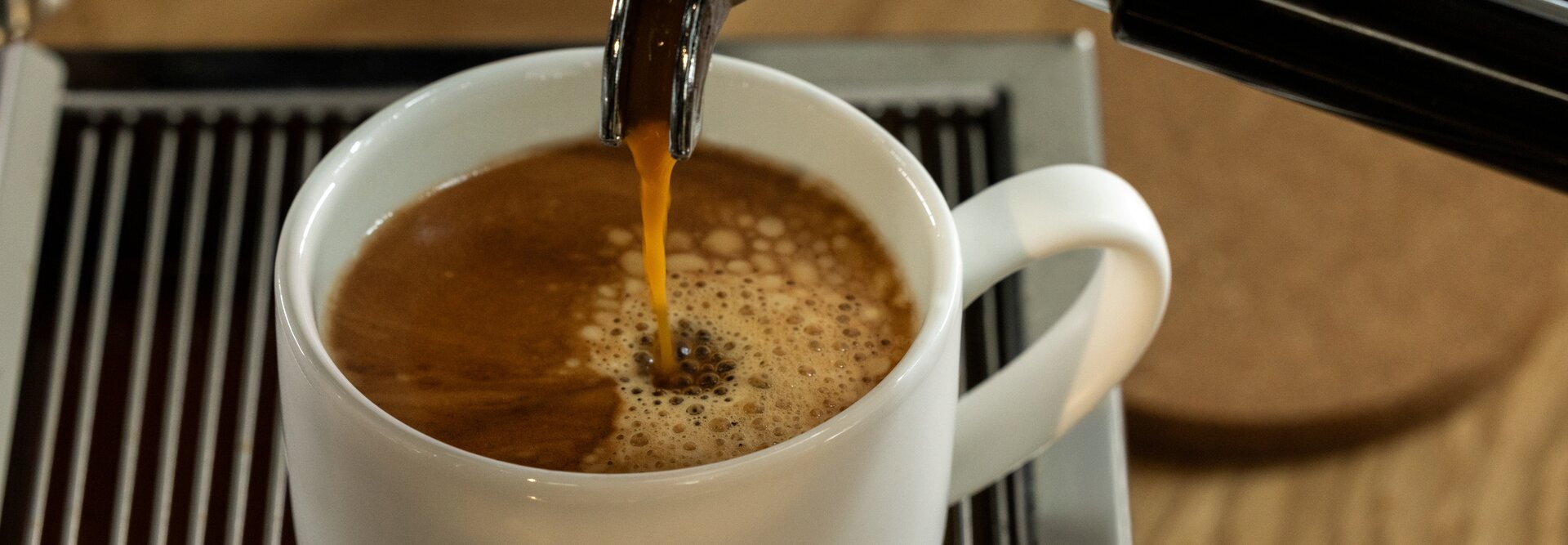 Un espresso riche versé dans une tasse Eilles, mettant en valeur la crème parfaite sur le café fraîchement infusé.