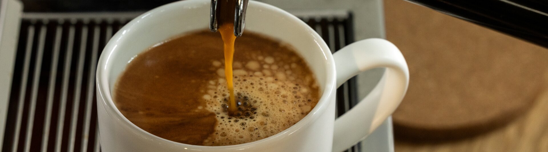 Un espresso riche versé dans une tasse Eilles, mettant en valeur la crème parfaite sur le café fraîchement infusé.