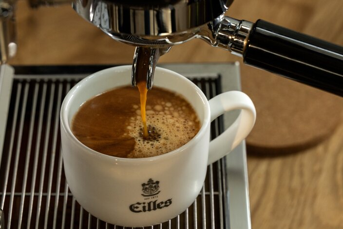Rich espresso pouring into an Eilles cup, showcasing the perfect crema atop the freshly brewed coffee.