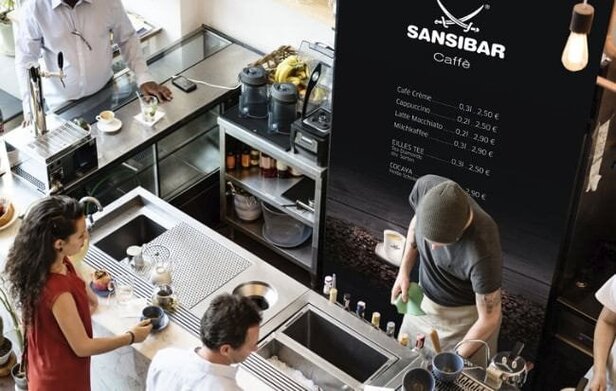 Eine lebhafte Café-Szene in der Sansibar, mit Baristas und Gästen, die Kaffee und Tee genießen.