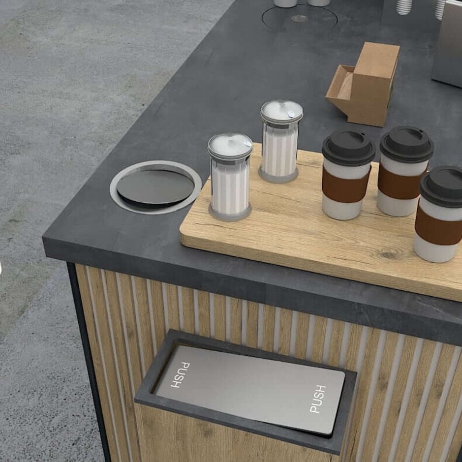 Coffee cups and condiments on a sleek café counter, with a person using a tablet to order or pay.