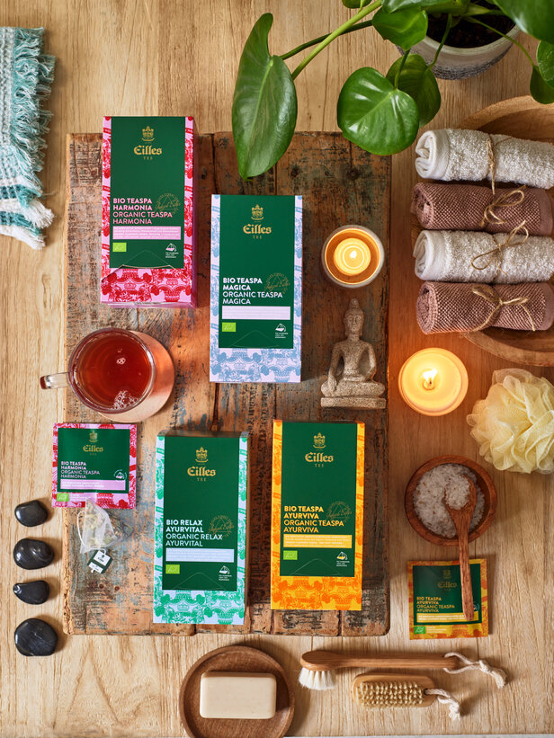 Eilles organic tea selection displayed with spa essentials, creating a serene relaxation atmosphere on wooden table.