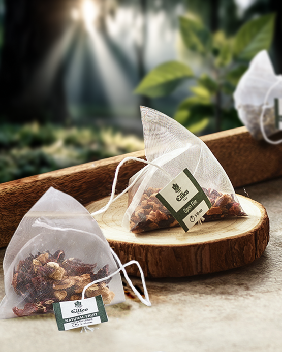 Prírodné ovocné čajové vrecúška vystavené na rustikálnom drevenom podnose, ktoré predstavujú pokojné prostredie inšpirované prírodou.