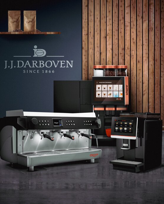 Stylové kávovary vystavené v moderním kavárenském prostředí se značkou J.J. Darboven a dřevěnými akcenty.