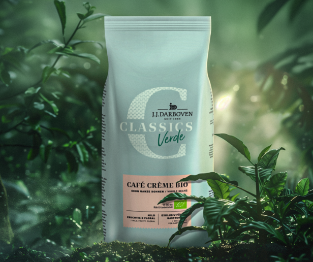 Organický kávový krém Bio od spoločnosti J.J. Darboven, vystavený uprostred sviežej zelene, ktorá zdôrazňuje jeho ekologické vlastnosti.