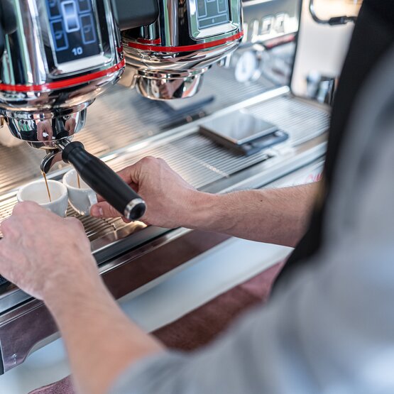 Ein Barista bereitet fachmännisch Espresso mit einer professionellen Kaffeemaschine zu und zeigt, wie man Kaffee zubereitet.
