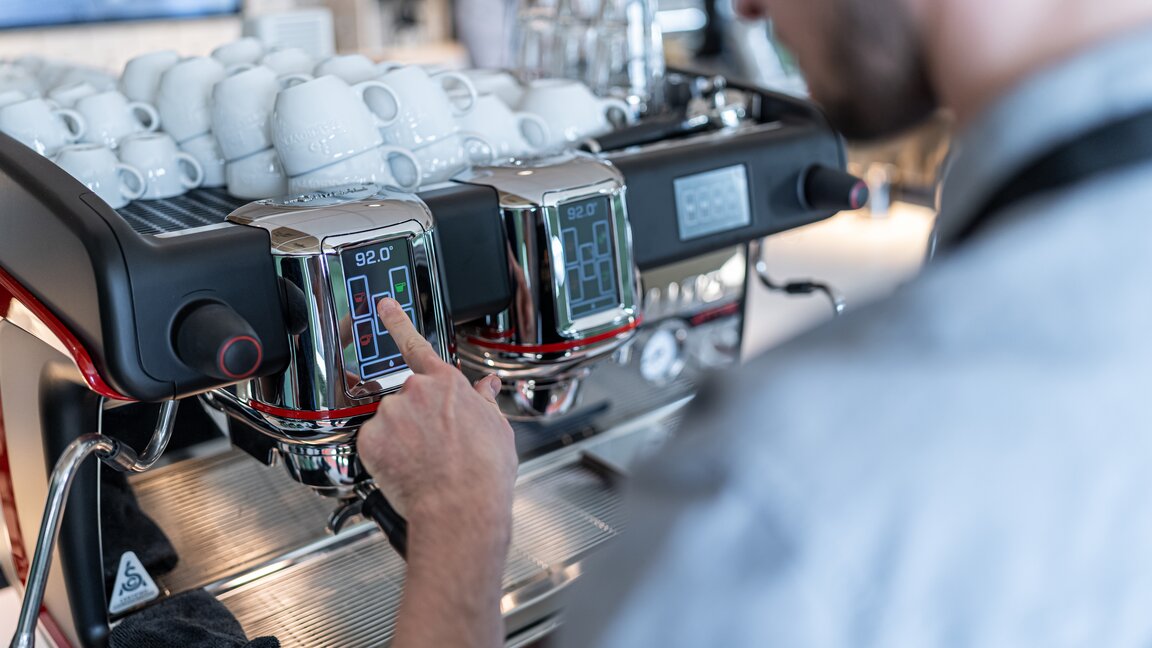 Barista réglant la température d'une machine à expresso dans une académie de café moderne.