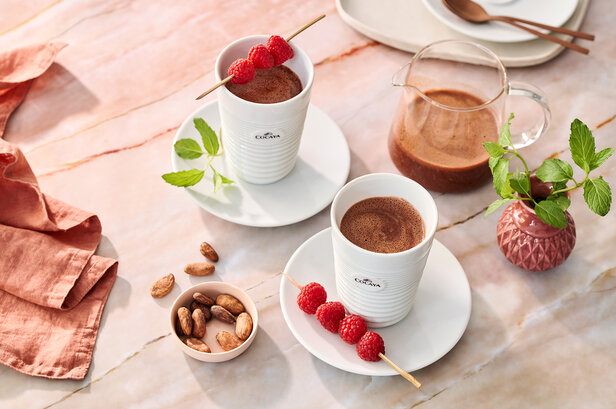 Köstlicher Cocaya-Himbeer-Smoothie, serviert mit Minze und Kakaobohnen auf einem Marmortisch, perfekt für einen erfrischenden Genuss.