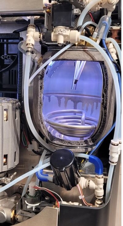 Innenansicht einer Kaffeemaschine, die die Pumpe, die Schläuche und die Komponenten für eine optimale Zubereitung zeigt.