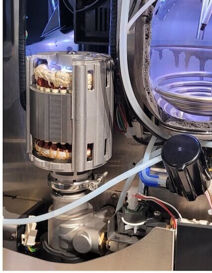 Interior view of a coffee machine showcasing its pump, tubing, and components for optimal brewing.