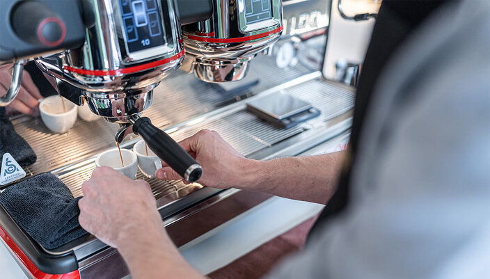 Expertly brewing espresso using a professional machine, capturing the artistry of coffee making.
