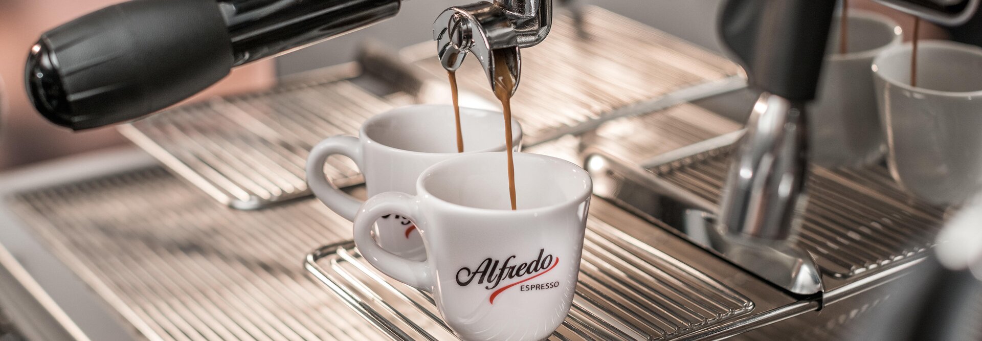 Bohaté espresso nalievané do dvoch šálok z kávovaru Alfredo, ktoré zvýrazňuje dokonalý nápoj milovníka kávy.
