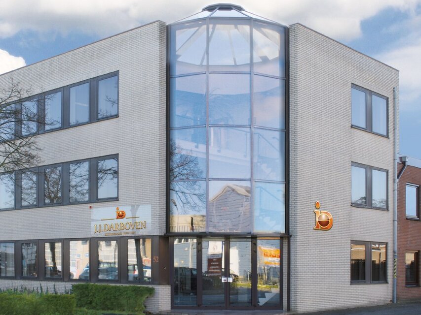 Modern office building exterior with large glass entrance, featuring J.J. Darboven signage in a business district.