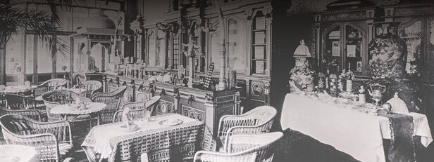 Interiér historickej kaviarne s elegantným nábytkom a dekoratívnymi predmetmi, ktoré prezentujú historický šarm a štýl.