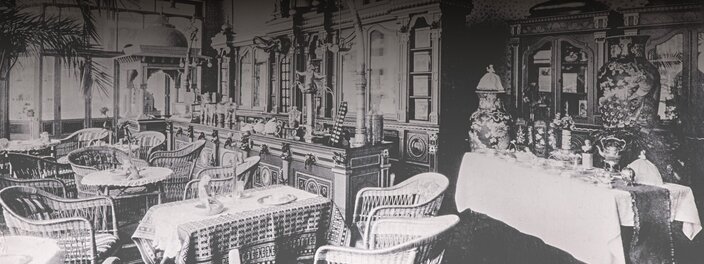 Historic café interior featuring elegant furniture and decorative pieces, showcasing vintage charm and style.